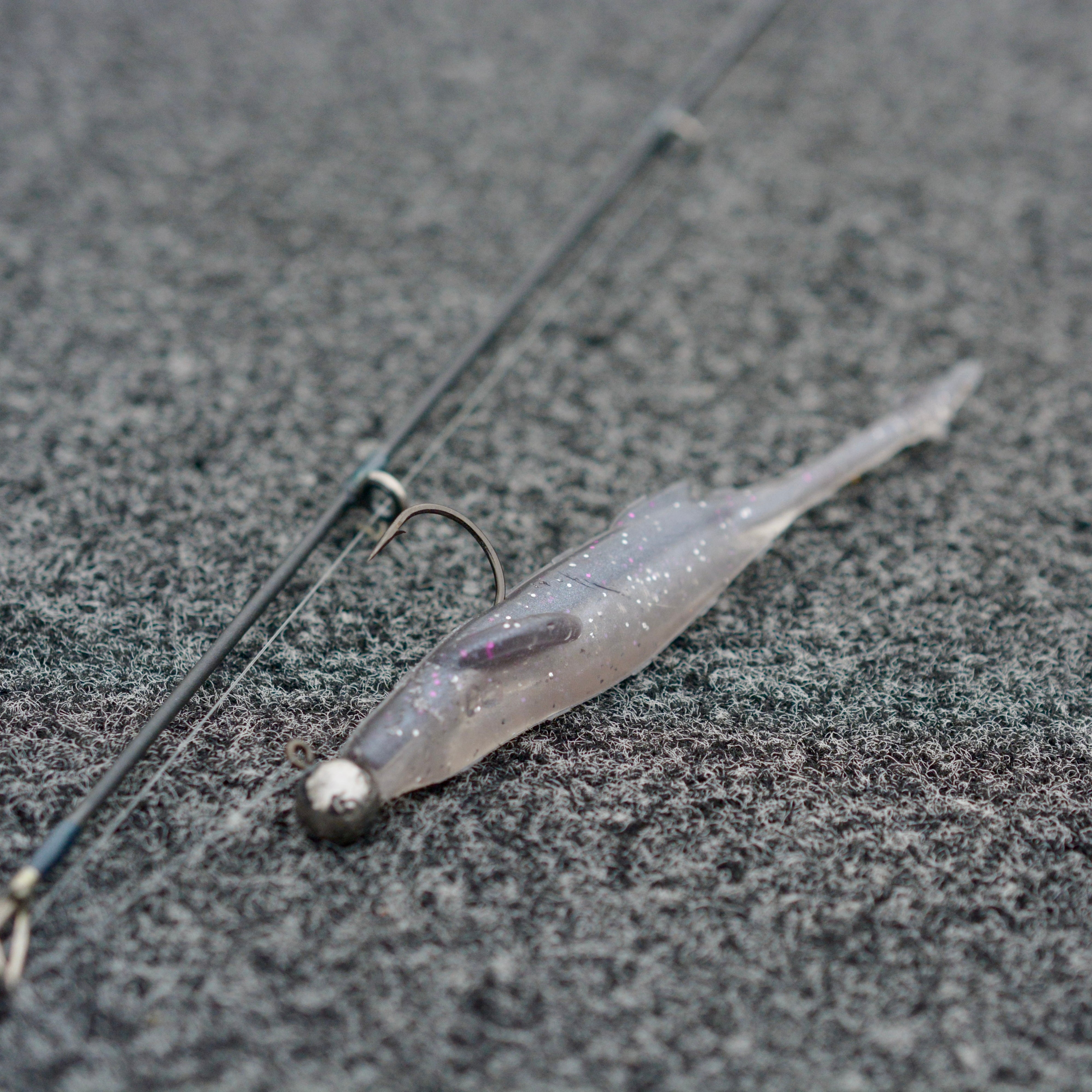 Purple Shad Motion Minnow rigged on a jig head laying on the deck of a boat. 